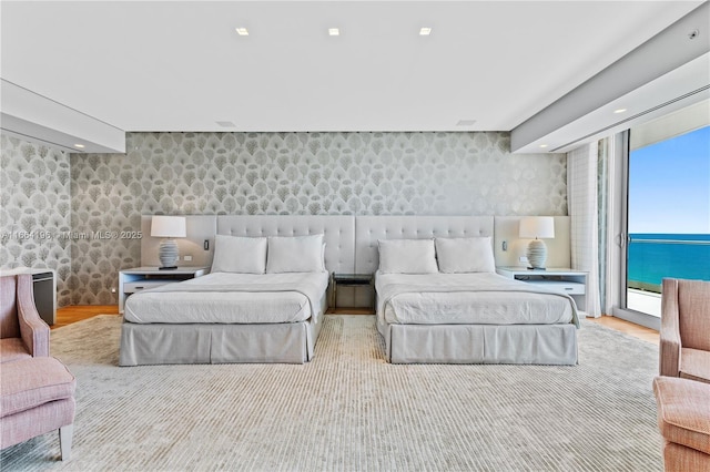 bedroom featuring access to exterior, recessed lighting, wood finished floors, and wallpapered walls