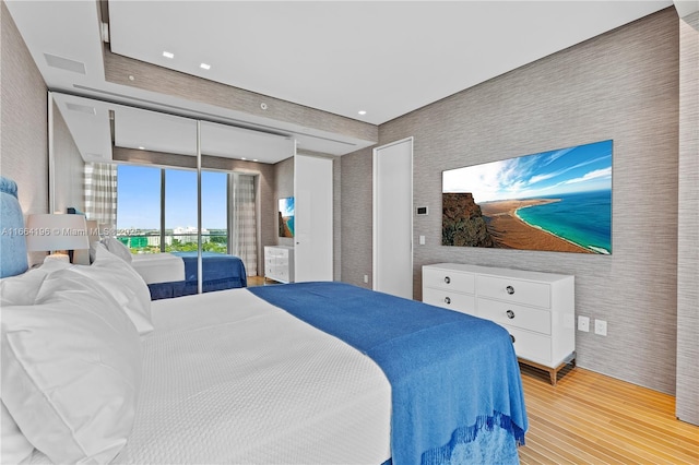 bedroom with light wood-style floors, wallpapered walls, and recessed lighting