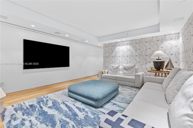 living room featuring hardwood / wood-style floors and a tray ceiling