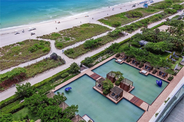 birds eye view of property with a water view and a view of the beach