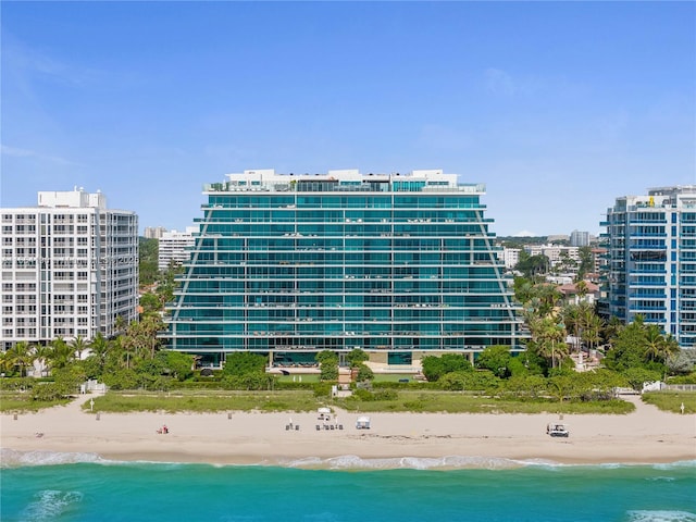 view of building exterior featuring a water view, a city view, and a beach view
