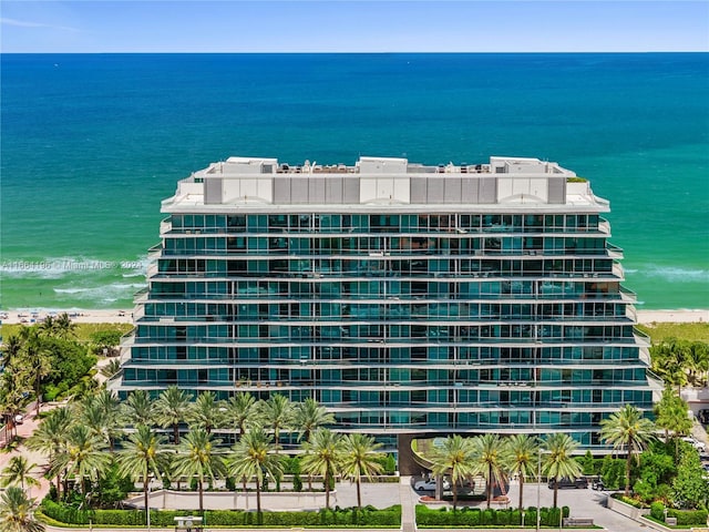 view of building exterior featuring a beach view and a water view