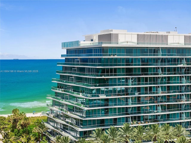 view of property with a water view and a beach view