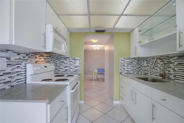 kitchen with white appliances, tasteful backsplash, white cabinetry, and light tile patterned floors