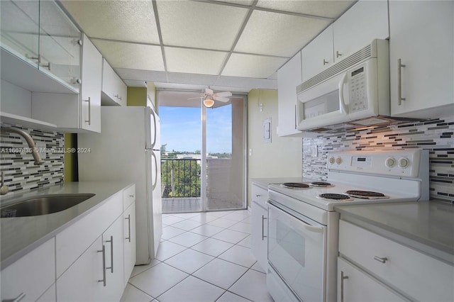 kitchen featuring white appliances, tasteful backsplash, and white cabinetry