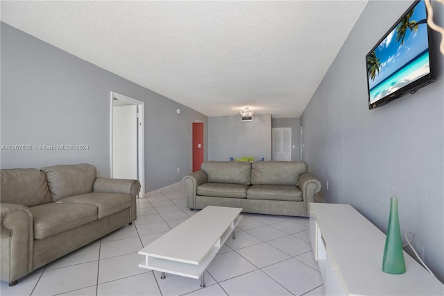 living room with a textured ceiling and light tile patterned floors