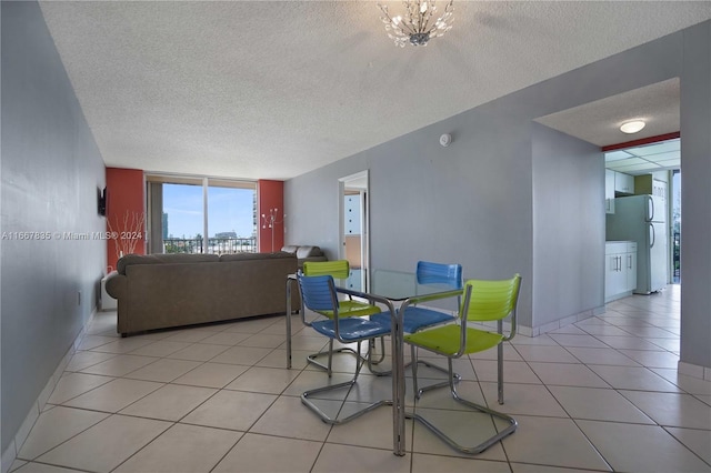 dining space featuring expansive windows, light tile patterned flooring, and a textured ceiling