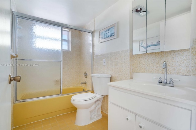 full bathroom featuring enclosed tub / shower combo, tile walls, toilet, vanity, and tile patterned flooring