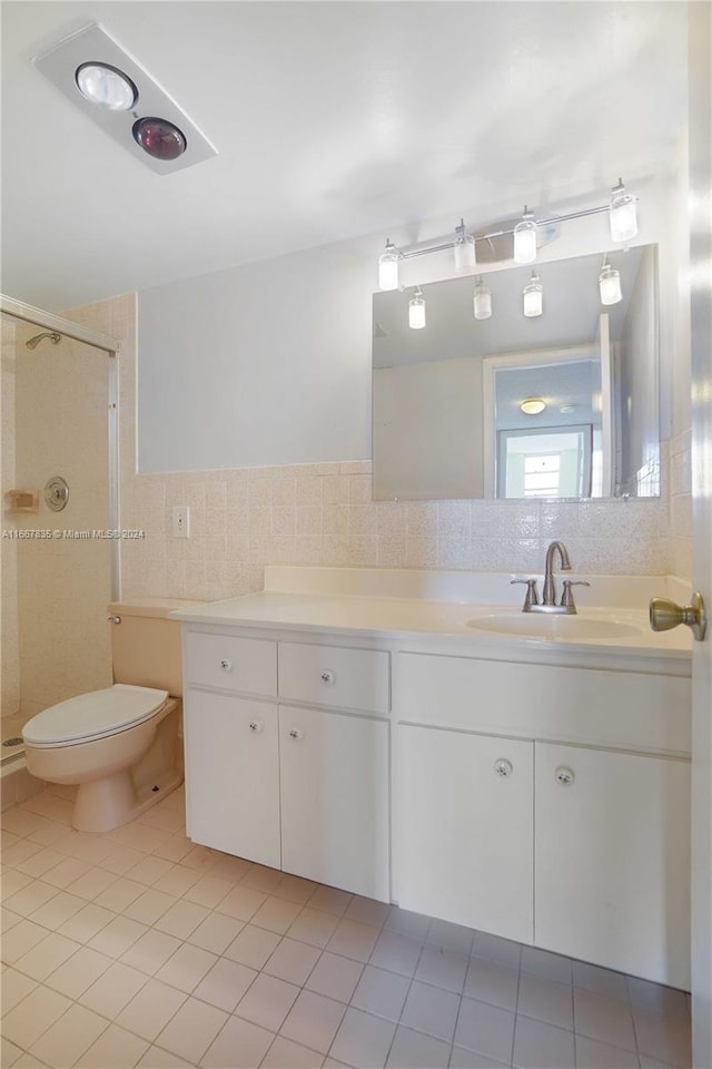 bathroom with tile walls, vanity, toilet, and walk in shower