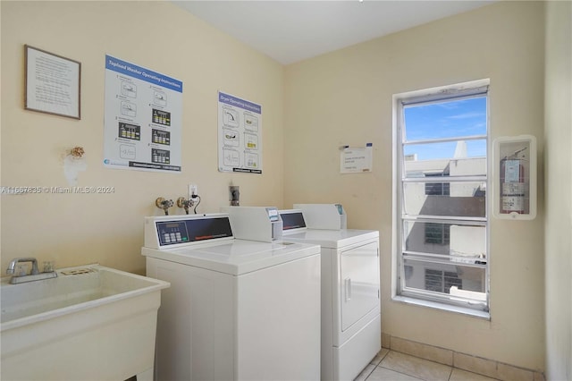 laundry area with sink, washer and clothes dryer, and light tile patterned floors