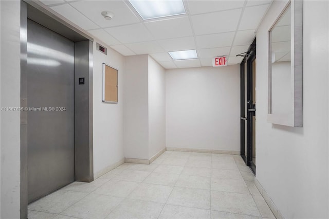 hallway featuring a drop ceiling and elevator