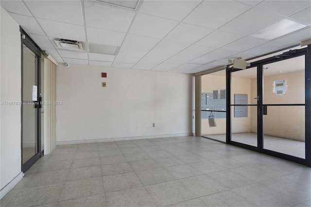 spare room with a wall of windows and a paneled ceiling