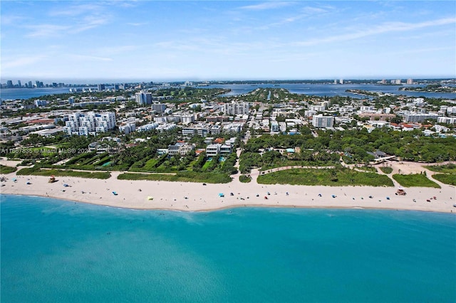 birds eye view of property with a water view and a beach view