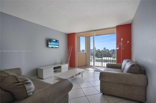 living room featuring a wall of windows, a textured ceiling, and light tile patterned floors