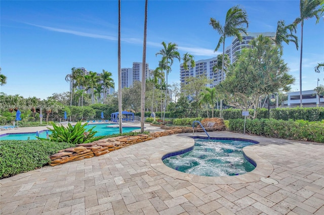 view of swimming pool featuring a patio area and a hot tub