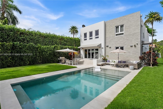 rear view of property with a patio, outdoor lounge area, and a lawn