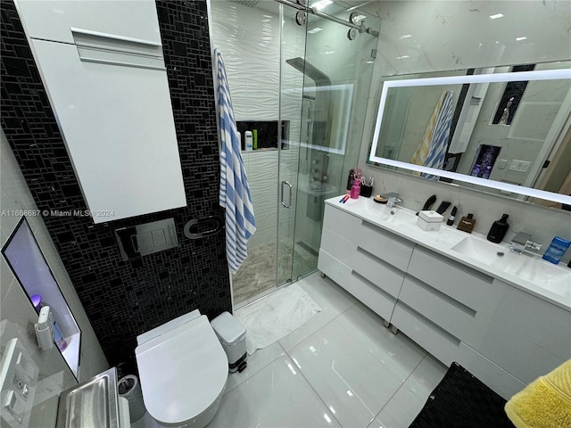 bathroom featuring tile walls, vanity, a shower with door, toilet, and tile patterned floors