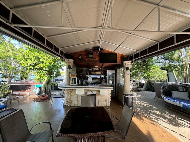 view of patio with exterior bar and a deck