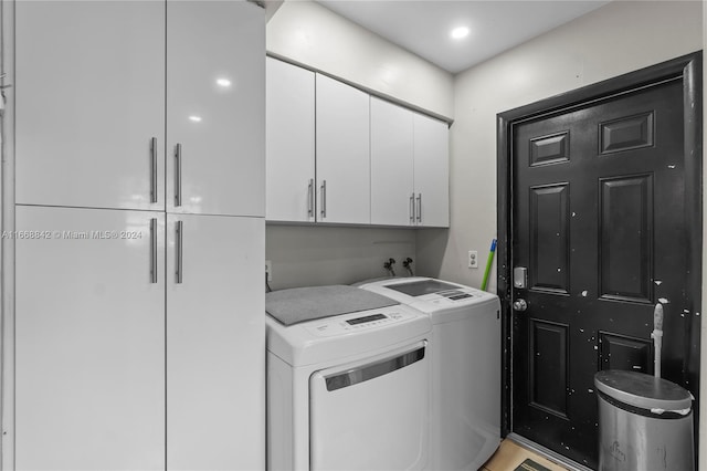 laundry room with separate washer and dryer and cabinets