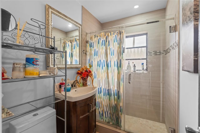 bathroom featuring a shower with door, vanity, and toilet