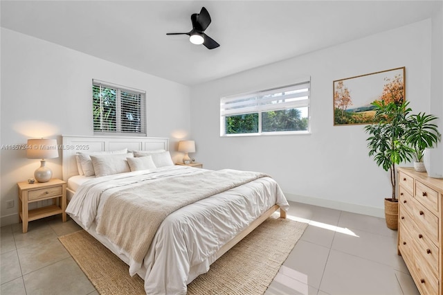 bedroom featuring a ceiling fan, baseboards, and light tile patterned floors