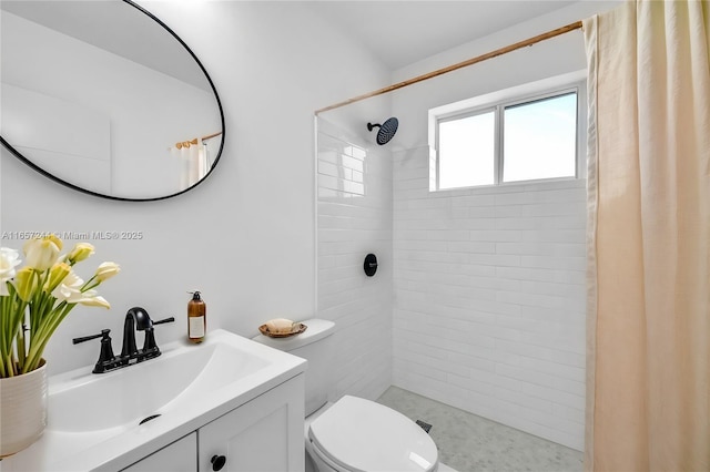 full bath featuring tiled shower, vanity, and toilet