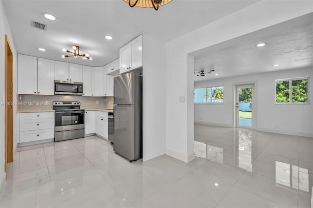 kitchen with visible vents, stainless steel appliances, a notable chandelier, and light countertops