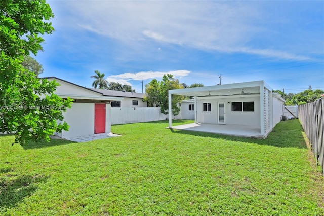 rear view of property with a lawn, a patio area, a fenced backyard, and stucco siding