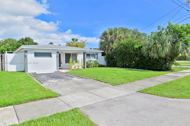 view of front of home with a front yard, fence, and stucco siding