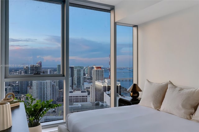 bedroom featuring a wall of windows and a water view