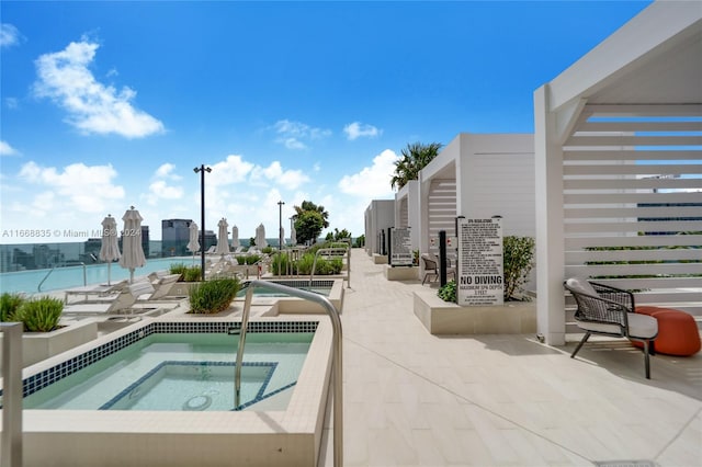 view of swimming pool featuring a patio area and a hot tub