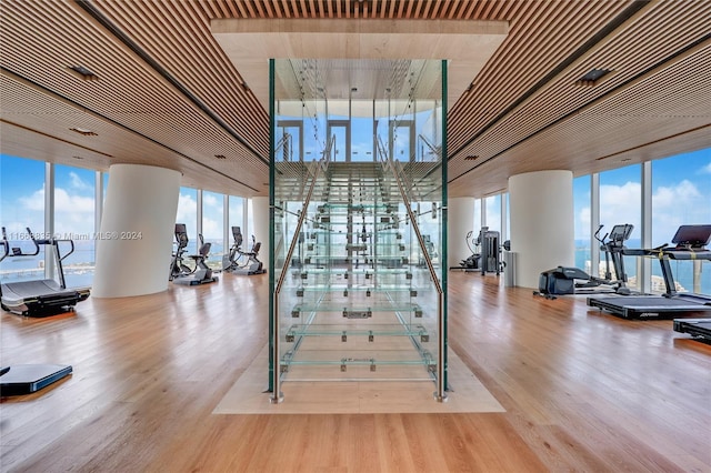 stairs featuring a wall of windows and hardwood / wood-style flooring