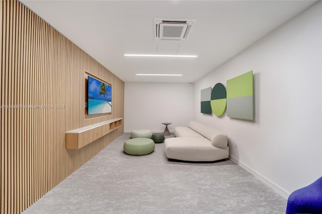 living area with attic access, baseboards, and carpet flooring