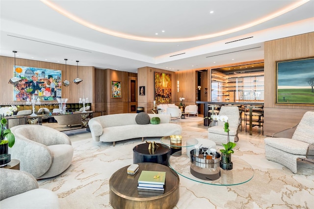 living room featuring wooden walls and a raised ceiling