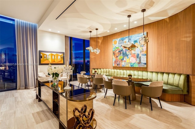 interior space featuring light hardwood / wood-style flooring, wooden walls, and hanging light fixtures