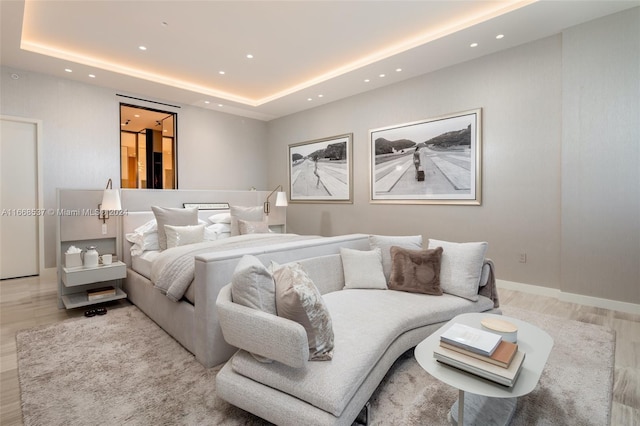 bedroom with a raised ceiling and hardwood / wood-style floors