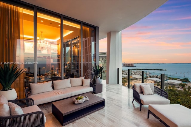 balcony at dusk with a water view and outdoor lounge area