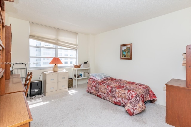 bedroom featuring a textured ceiling and light colored carpet