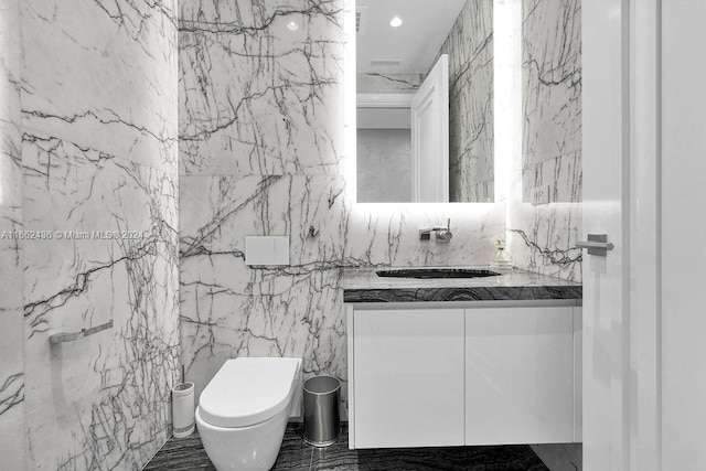 bathroom with vanity, tile walls, and toilet