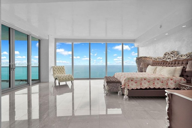 bedroom with a wall of windows, multiple windows, access to exterior, and a water view