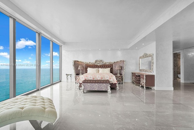 bedroom featuring expansive windows, access to exterior, and a water view