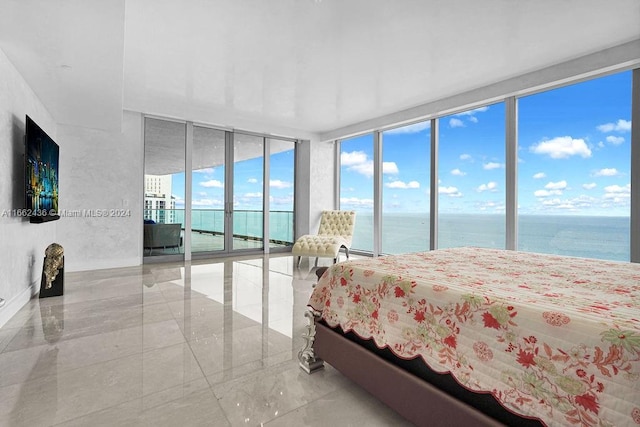 bedroom with access to outside, a wall of windows, and a water view