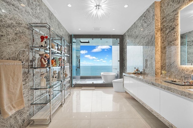 bathroom with a water view, tile walls, vanity, and shower with separate bathtub