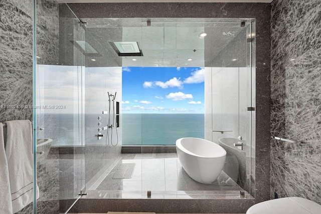 bathroom featuring independent shower and bath, tile walls, a water view, and tile patterned floors