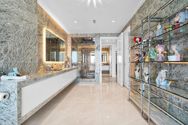 bathroom featuring vanity and tile walls