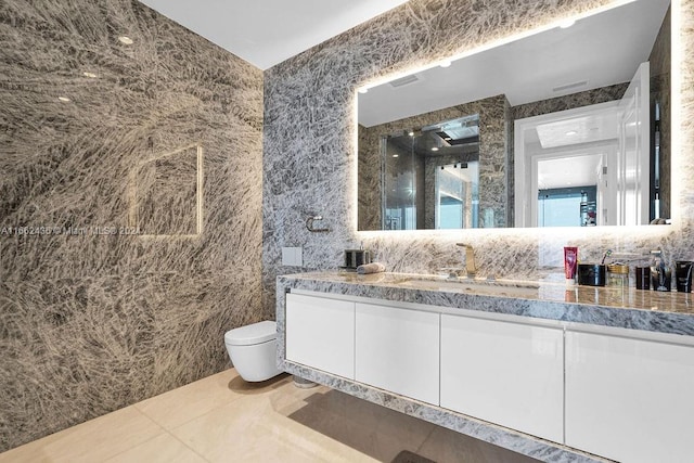 bathroom featuring vanity, tile walls, tile patterned flooring, and toilet