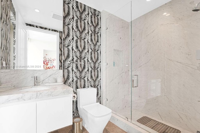 bathroom with tile walls, a shower with shower door, vanity, and toilet