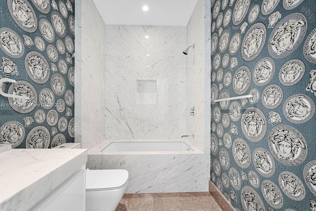 full bathroom with tile patterned flooring, tiled shower / bath combo, vanity, and toilet