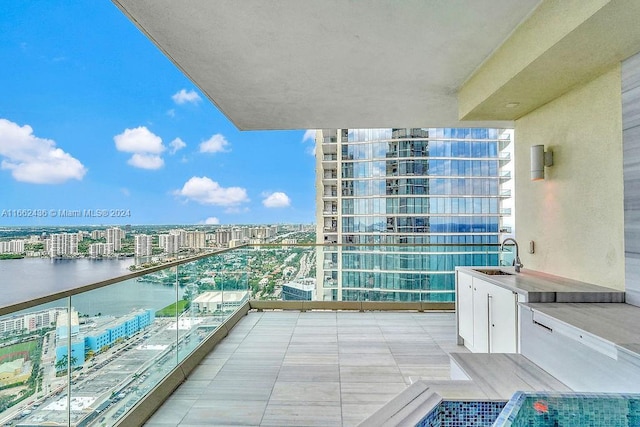 balcony featuring a water view and sink