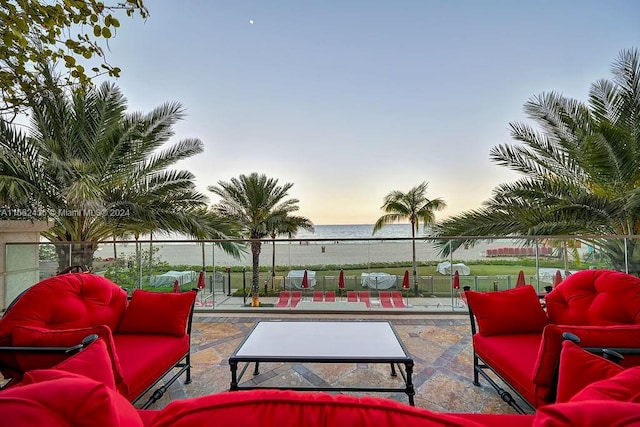 patio terrace at dusk featuring a water view